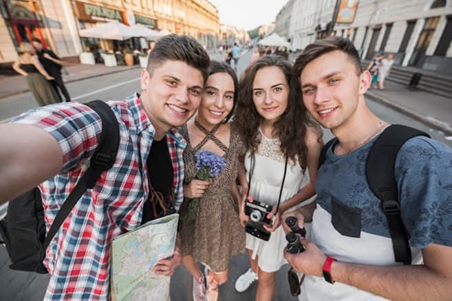 Group of friends taking a selfie while exploring a historic city street